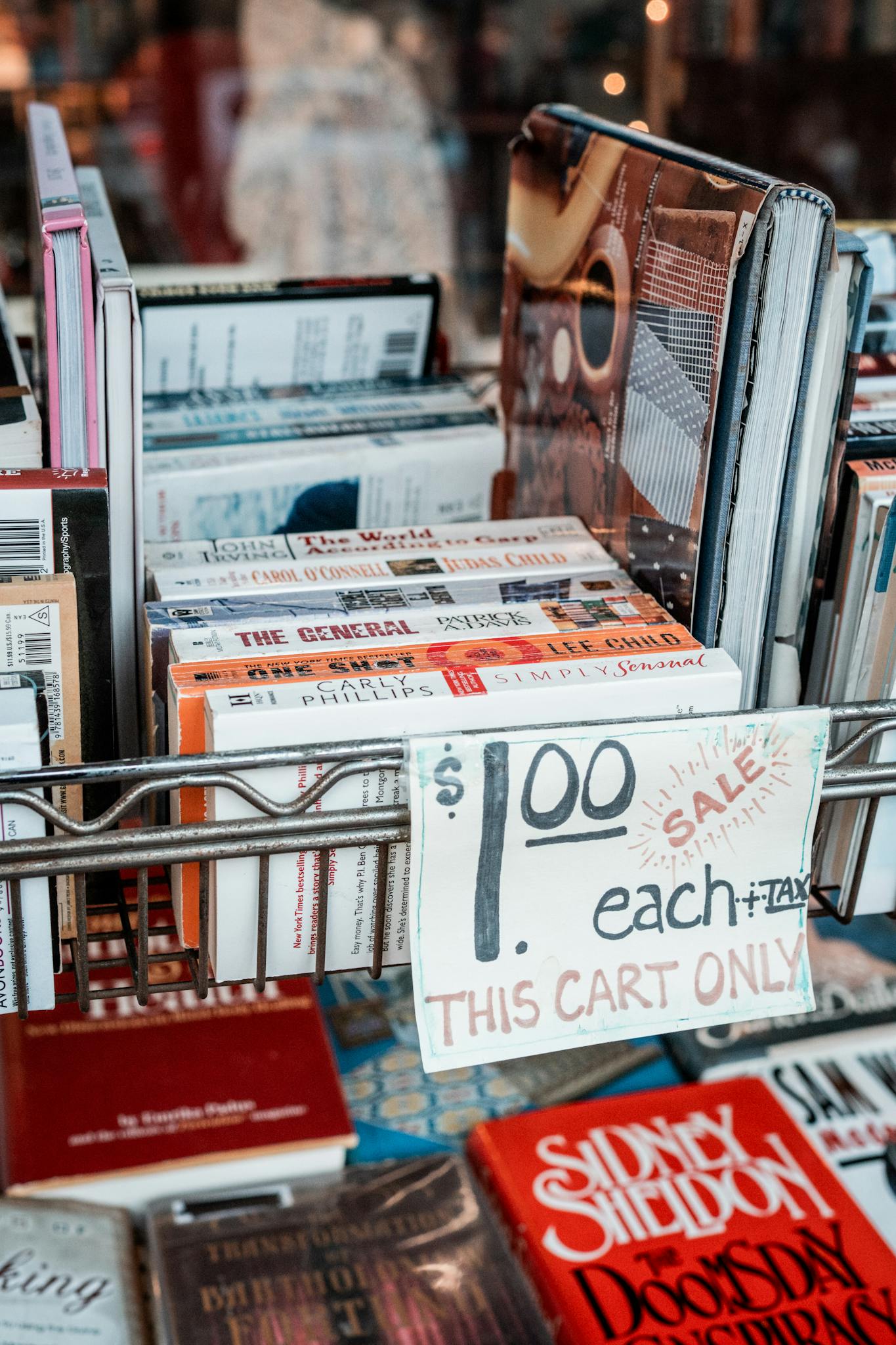 A cart filled with used books sold for $1 each, perfect for bargain hunters.